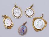three gold - plated pendants with a picture of a woman and a man