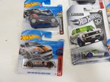 three hot wheels cars in the package on the table