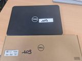 Des ordinateurs portables Dell sont posés sur une table, avec une étiquette de prix dessus.