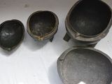 several old metal pots and pans sitting on a table