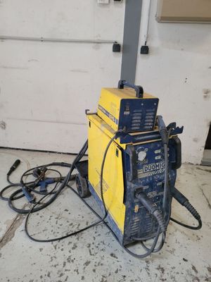 une photo d'une soudeuse posée par terre dans un garage