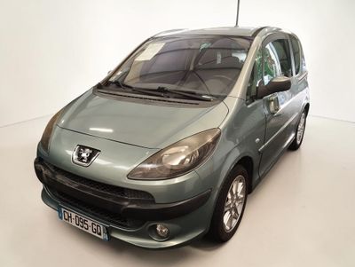 une petite voiture grise garée dans une pièce blanche