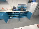 a man that is standing in front of a counter with bottles of water