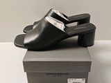 the black leather mulers are on top of a box