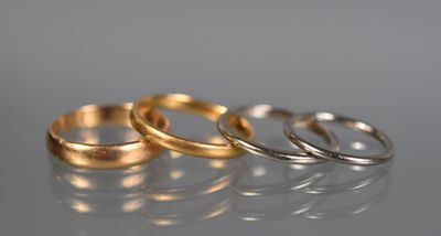 three gold and silver rings on a reflective surface