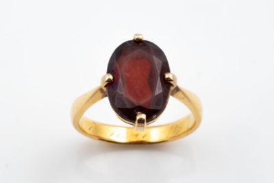 an oval garnet garnet stone set in a yellow gold ring