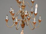 un lustre ancien en laiton à cinq lumières, orné d'un pompon suspendu au plafond