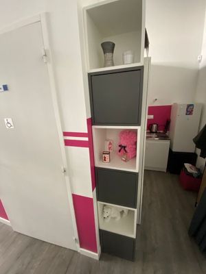 a tall cabinet in the corner of a small room