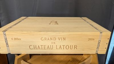 une boîte en bois sur laquelle est collée une étiquette, posée sur une chaise