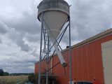 a water tower sitting next to a building on the side of the road