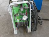 a green machine that is sitting in a garage