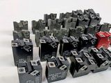 a pile of black and red electrical switches on a white surface