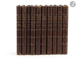 six old books lined up in a row on a white surface