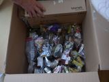 a man that is opening a box with a lot of candy in it