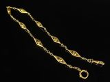 a gold chain with a clasp on a black background