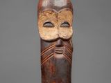 a wooden mask with a face and a beard