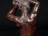 bronze sculpture of a woman sitting on her back with her hands on her head