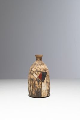 un petit vase orné d'un motif rouge et noir