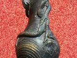 un vase noir orné d'un dragon, posé sur une table