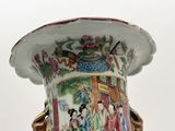 a vase with a painting on it sitting on a table