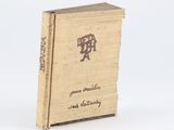 un vieux livre portant des caractères chinois, posé sur une surface blanche