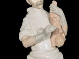 a figurine of a man holding a baby in his arms