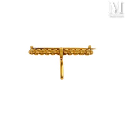 un gros plan d'une broche en or ornée d'une croix