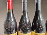three bottles of red wine are lined up on a table