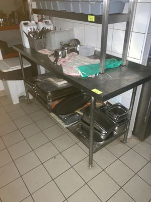 une étagère métallique avec des casseroles et des poêles dans une cuisine