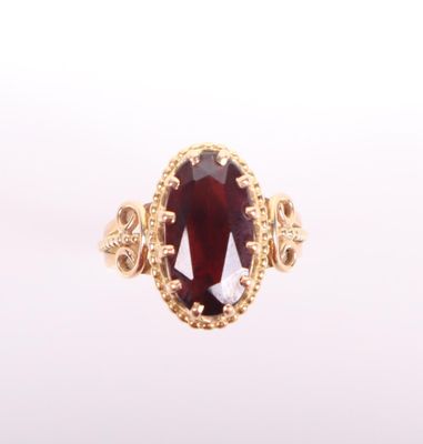 Gros plan sur une bague contenant une pierre rouge