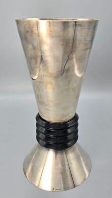 une image représentant un vase argenté avec un socle noir