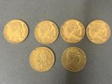 six gold sovereigns of different sizes and shapes