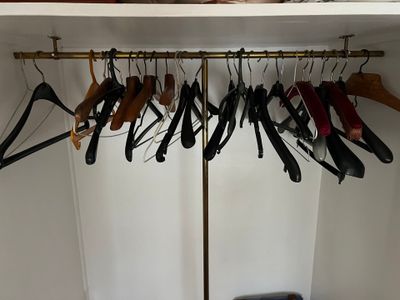 a closet with several pairs of shoes hanging on a rack