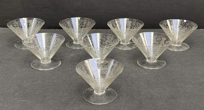 six clear glass goblets sitting on top of a table