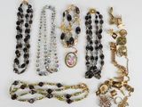 many necklaces and bracelets laid out on a table