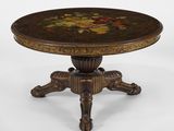 une table ronde dont le plateau est orné d'un motif floral