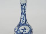 a small blue and white vase with a design on it