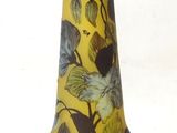 a yellow vase with birds on it sitting on a table