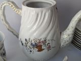 a white tea pot sitting next to a stack of plates
