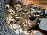 une statue en bronze représentant une personne tenant un chien