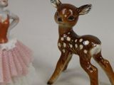 two figurines of a deer and a ballerina on a table