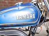 a close up of a yamaha motorcycle parked in front of a brick wall
