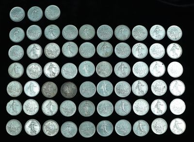a lot of silver coins on a black surface