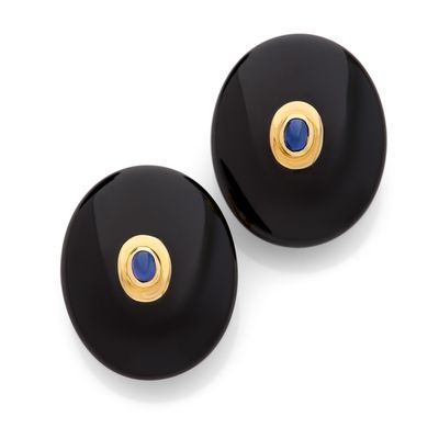 une paire de boucles d'oreilles noires et dorées ornées d'une pierre bleue