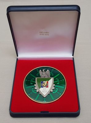 la médaille se trouve dans une boîte rouge posée sur une surface blanche