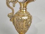 an antique brass vase with a bird on the top of it