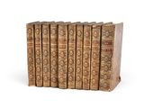six vieux livres alignés sur une surface blanche