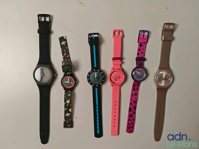 plusieurs montres différentes sont alignées sur une surface blanche