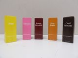 four boxes of perfume are lined up on a white surface