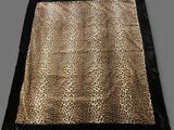 a leopard print blanket on a grey background